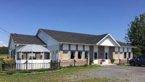 ein Haus mit einem Zaun davor in der Unterkunft Maison du Moulin in L'Isle-aux-Coudres