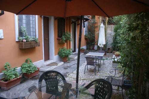 a patio with a table and chairs and an umbrella at Affittacamere Villa Wilson in Rome