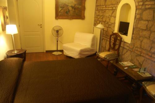 a living room with a bed and a chair at Affittacamere Villa Wilson in Rome