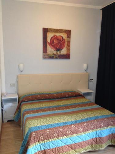 a bedroom with a bed with a painting on the wall at Hotel Domodossola in Domodossola