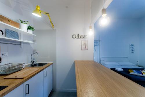 a kitchen with a counter and a sink and a bed at Capofortuna B&B Salerno Centro in Salerno