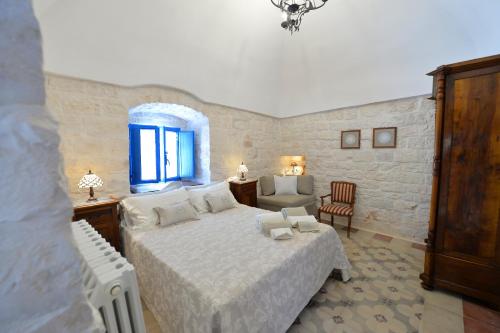 a bedroom with a large bed and a window at Masseria Oreglia in Ceglie Messapica