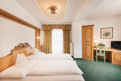 pokój hotelowy z 2 łóżkami i telewizorem w obiekcie Hotel Hoferwirt w Neustift im Stubaital