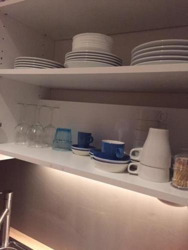a shelf with plates and cups and dishes on it at Suite 11 in Antwerp