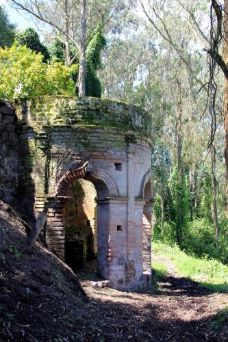an old stone bridge with an arch in a forest at Hostería Hacienda Pinsaqui in Otavalo