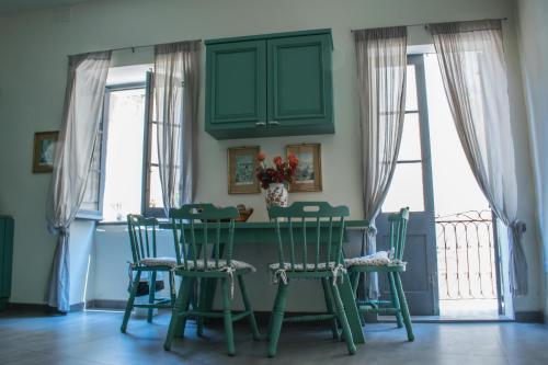Melita corner apartment في فاليتا: غرفة طعام مع كراسي خضراء وطاولة