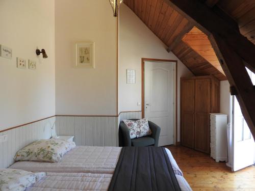 une chambre avec un lit et une chaise dans une pièce dans l'établissement Le Moulin De Saussaye, à Crouzilles