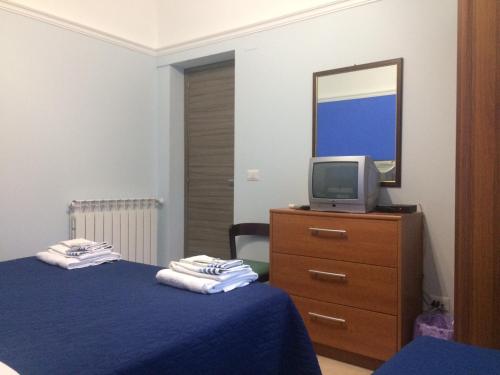 a bedroom with a bed and a tv on a dresser at Etna Case Mangano in Linguaglossa