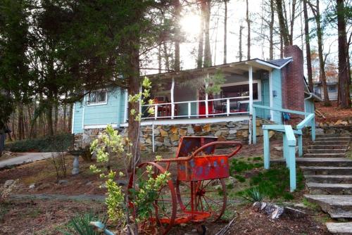 a blue house with two red chairs in front of it at The Pines Cottages in Asheville
