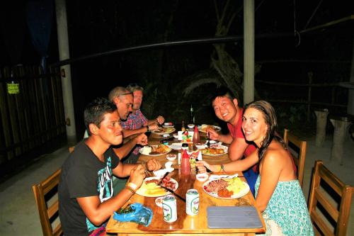 a group of people sitting around a table eating food at B&B, family run homestay, Hospedaje La Penita in Altagracia