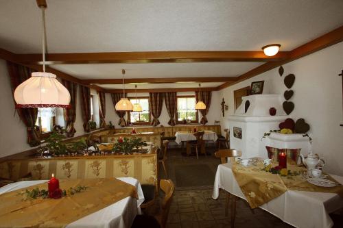 a dining room with two tables and a kitchen at Seepension Knappenhof in Pertisau