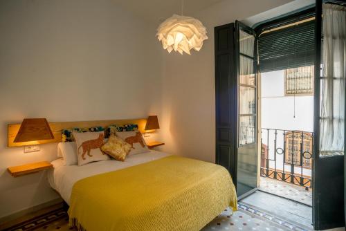 een slaapkamer met een bed met een gele deken bij Eva Recommends Casa Gerona in Sevilla