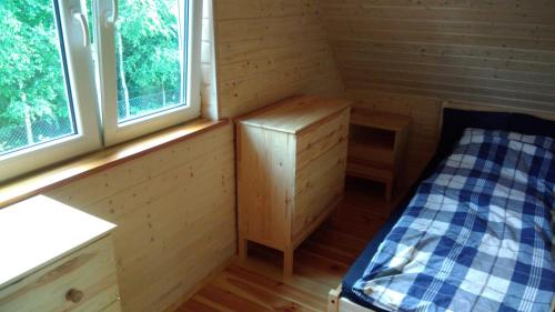 a small cabin with a bed and two windows at Domek nad morzem Mechowo in Mechowo