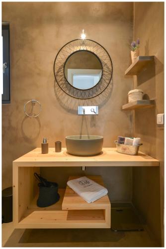 a bathroom with a sink and a mirror on a shelf at San Romano Villas in Agios Romanos