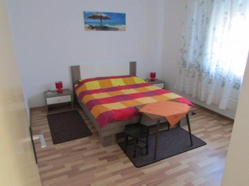 - une petite chambre avec un lit et une table dans l'établissement Apartments Sandra, à Novigrad