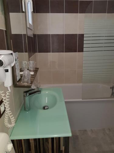 a bathroom with a sink and a bath tub at Hôtel Port Beach in Gruissan
