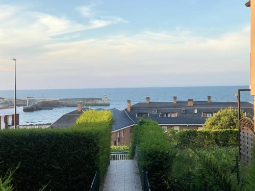 a view of the ocean from a building at Casa de Las Flores - Apartamento con jardín privado frente a la Playa de Comillas in Comillas