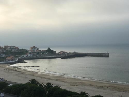 a view of a beach with houses and the ocean at Casa de Las Flores - Apartamento con jardín privado frente a la Playa de Comillas in Comillas
