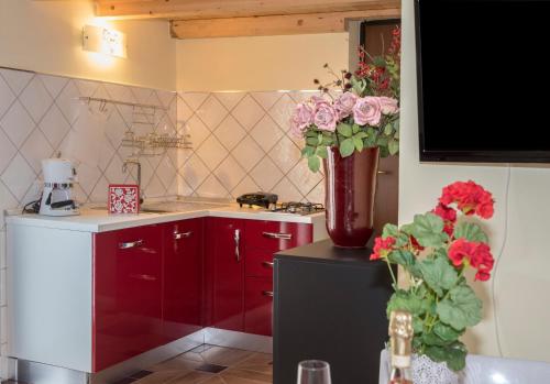 a kitchen with a vase of flowers on top of a refrigerator at B&B Borgo Marinella in Sapri