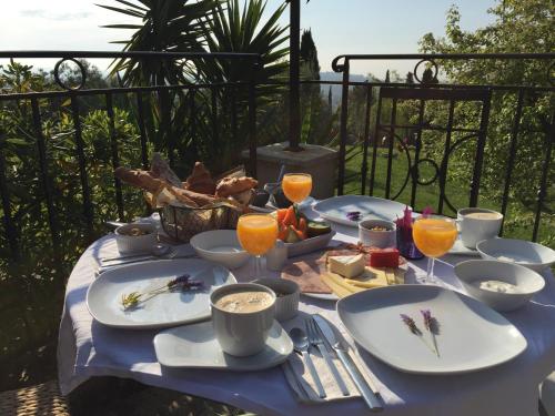 a table with plates of food and glasses of orange juice at Les 4 éléments in Tourrettes-sur-Loup