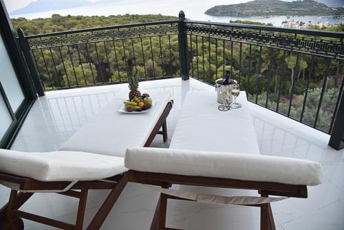 a table and chairs on a balcony with a view at AKRON Luxury Holidays in Ancient Epidavros