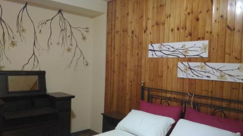 una camera con letto e parete in legno di Locazione Turistica Casa Vacanza Lola a Castiglion Fiorentino