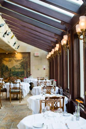 a dining room with white tables and chairs at Prince of Wales in Niagara on the Lake