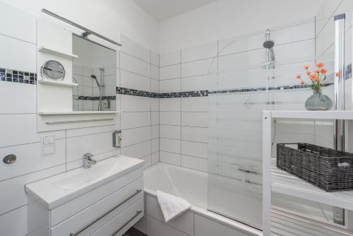 ein weißes Badezimmer mit Badewanne und Waschbecken in der Unterkunft Family-Apartments Freiburg in Freiburg im Breisgau