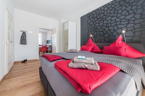 um quarto com uma cama grande e almofadas vermelhas em Family-Apartments Freiburg em Friburgo em Brisgóvia