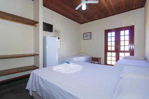 a room with two beds and a refrigerator at Pousada Príncipe dos Mares in Paraty