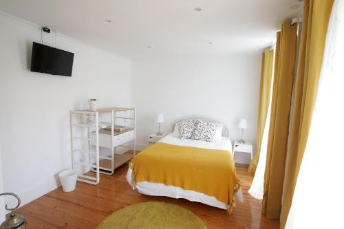 リスボンにあるArroios de Paixaoのベッドルーム1室(黄色い毛布付きのベッド1台付)
