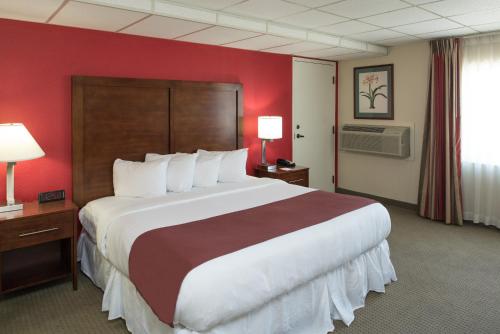 a hotel room with a large bed and red walls at Ramada by Wyndham Downtown Spokane in Spokane