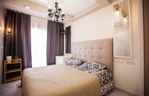 a bedroom with a large bed and a chandelier at Orlando Ocean Star in Adeje