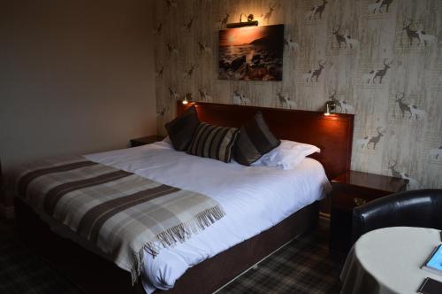 a bedroom with a large bed with white sheets at Orchard Lodge & Wolds Restaurant in Scarborough