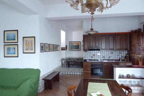 ein Wohnzimmer mit einem Tisch und einer Küche in der Unterkunft Appartamento Confortevole I 3 cocos in Maierato