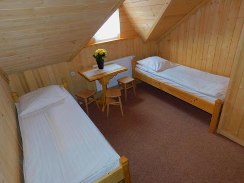 una habitación con 2 camas y una mesa y un asterisco en Dom wypoczynkowy U Kuby, en Białka Tatrzanska