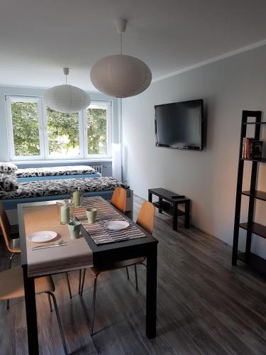 a living room with a table and a bed at Apartament Pocztowa in Drawsko Pomorskie