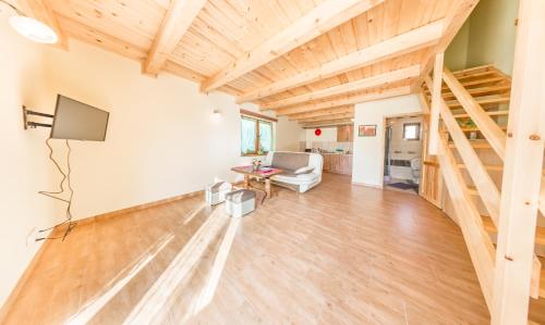 a living room with wooden ceilings and a wooden floor at Bobrówka in Solina