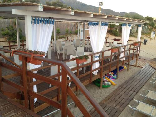 a pergola on a patio with a table and chairs at Ganimede Hotel in Sperlonga