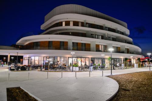 a building with a lot of windows at night at Apartamenty Na Wyspie - Baltic Molo - Parking in Świnoujście