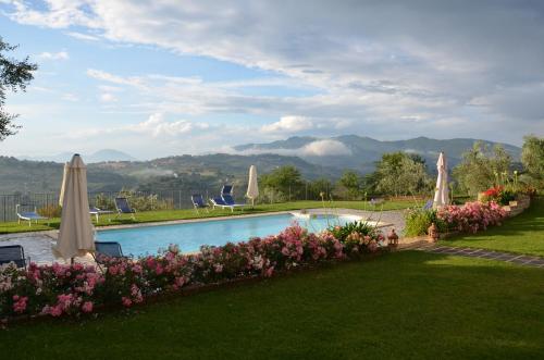 a swimming pool with umbrellas and flowers at Villa Collebelvedere - Near Rome with Home Restaurant in Fara in Sabina