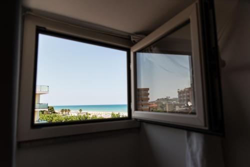 a window with a view of the beach at Cristallo Verde Mare in Alba Adriatica