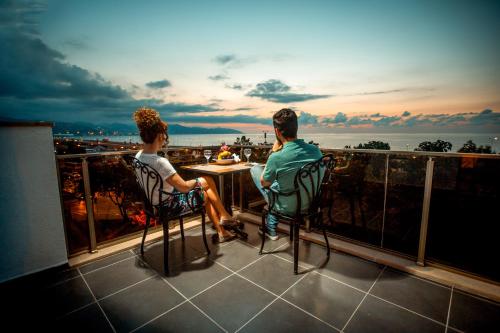 two people sitting on a balcony watching the sunset at Blue Sea Hotel in Trabzon
