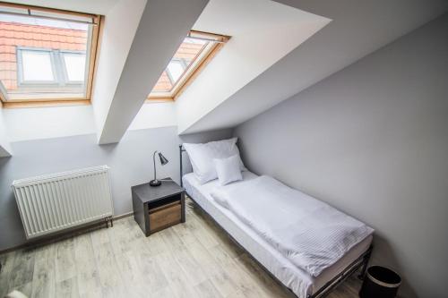 a small bedroom with a bed and a lamp on a table at Pension Viktorin in Poděbrady