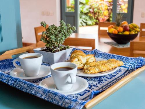 a tray with two cups of coffee and pastries on a table at Casa Barichara Boutique in Barichara
