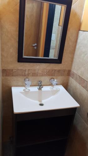 a bathroom with a white sink and a mirror at Arbolada Talas del Tuyu in San Clemente del Tuyú