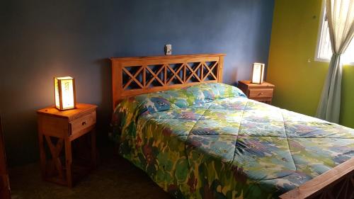 a bedroom with a bed and two night stands with lamps at Arbolada Talas del Tuyu in San Clemente del Tuyú