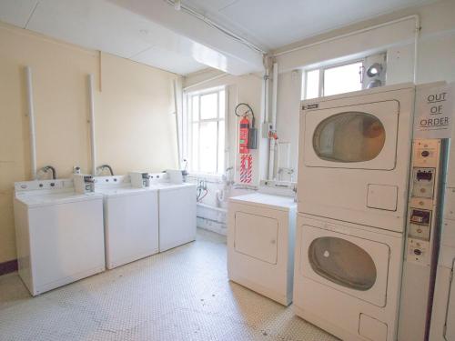 a laundry room with three sinks and a washing machine at Hotel Waterloo & Backpackers in Wellington