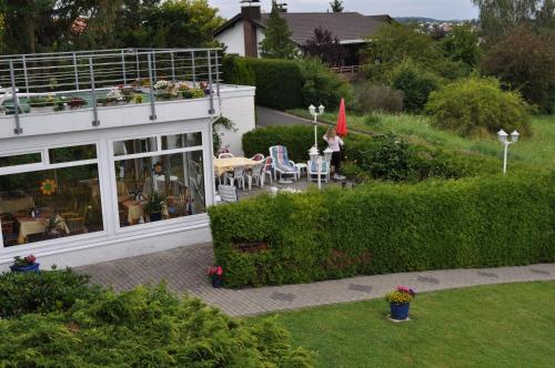 Eine Frau steht in einem Garten neben einem Gebäude in der Unterkunft Haus Mariann in Bad Wildungen