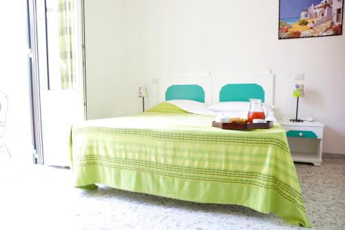 a bedroom with a bed with a green blanket at Casa Baia Luna in Ponza